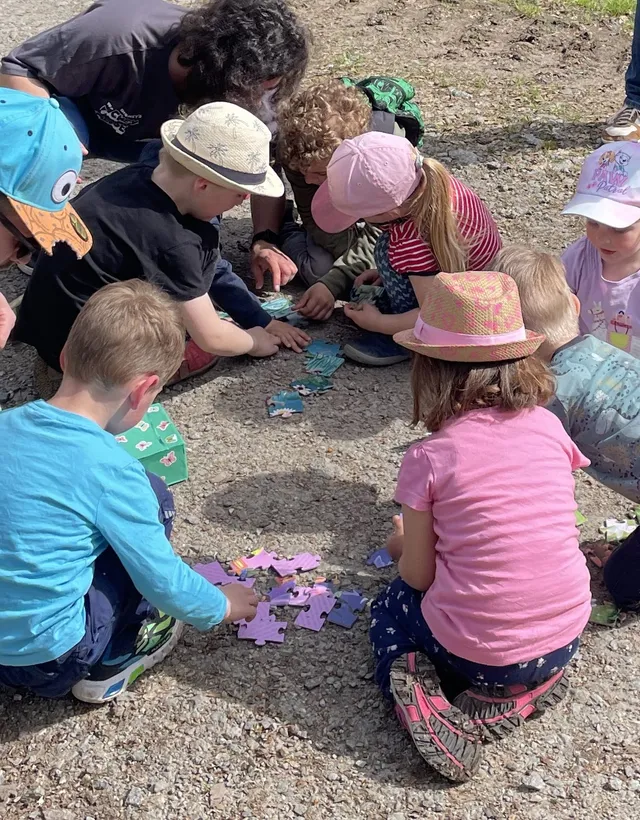 Kinder lösen gemeinsam eine Puzzle-Station bei einer Schnitzeljagd